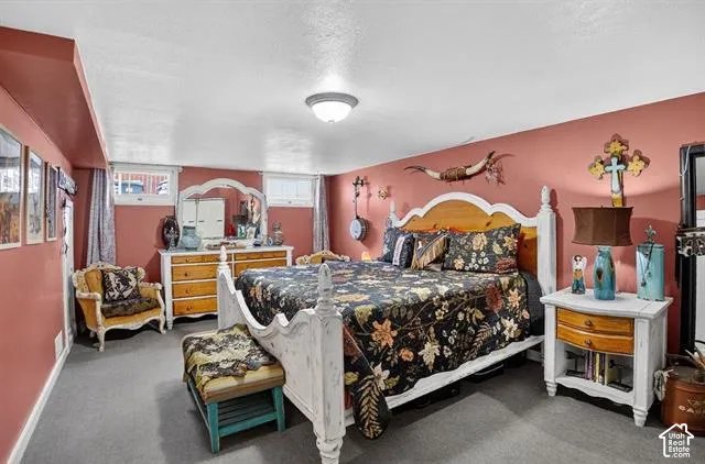 Carpeted bedroom featuring painted walls, a flush-mount ceiling light, and multiple windows