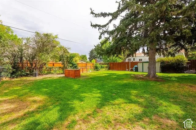Expansive lawn area with mature trees and perimeter fencing