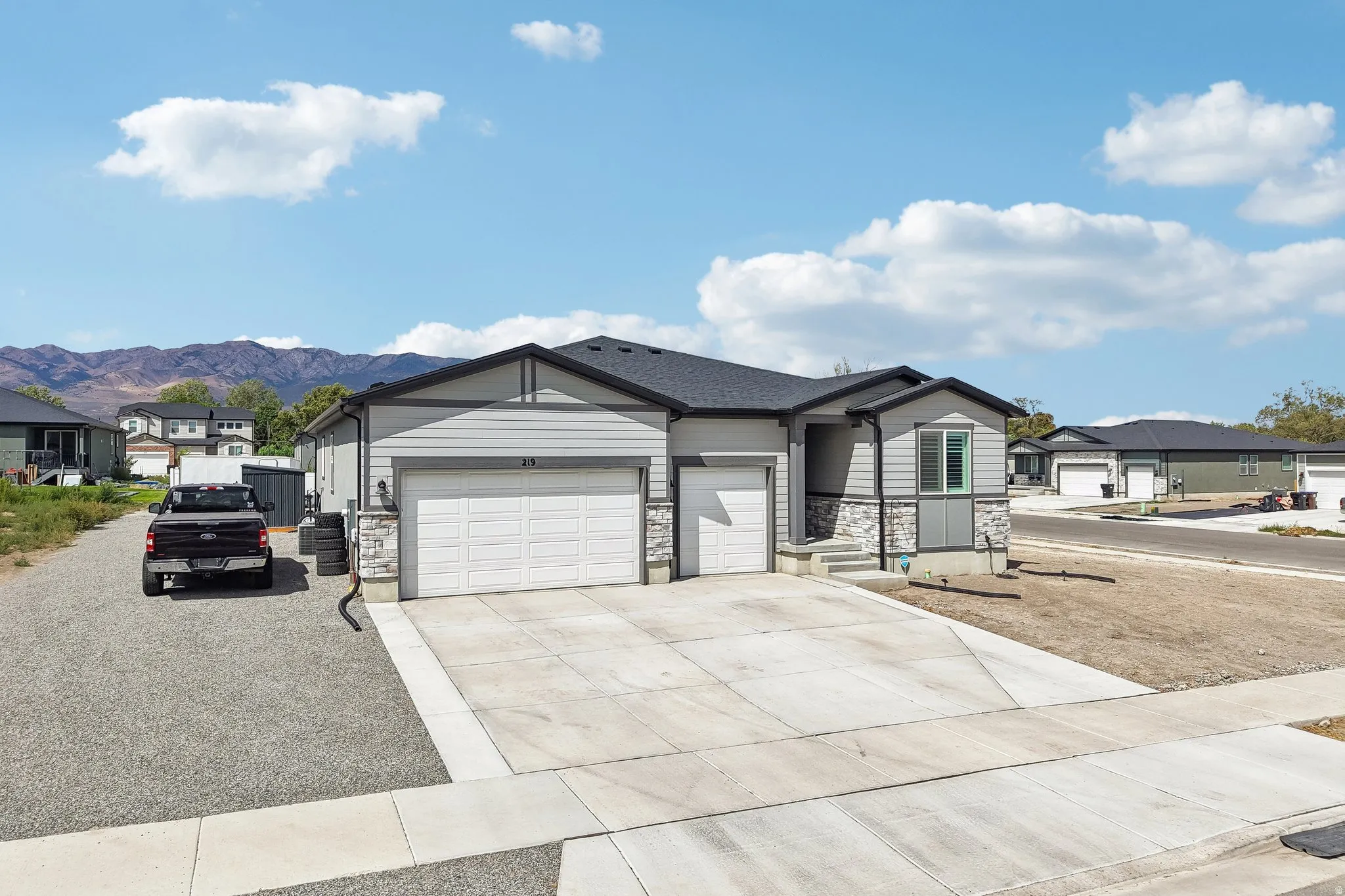 Contemporary exterior featuring gray siding and stone accents