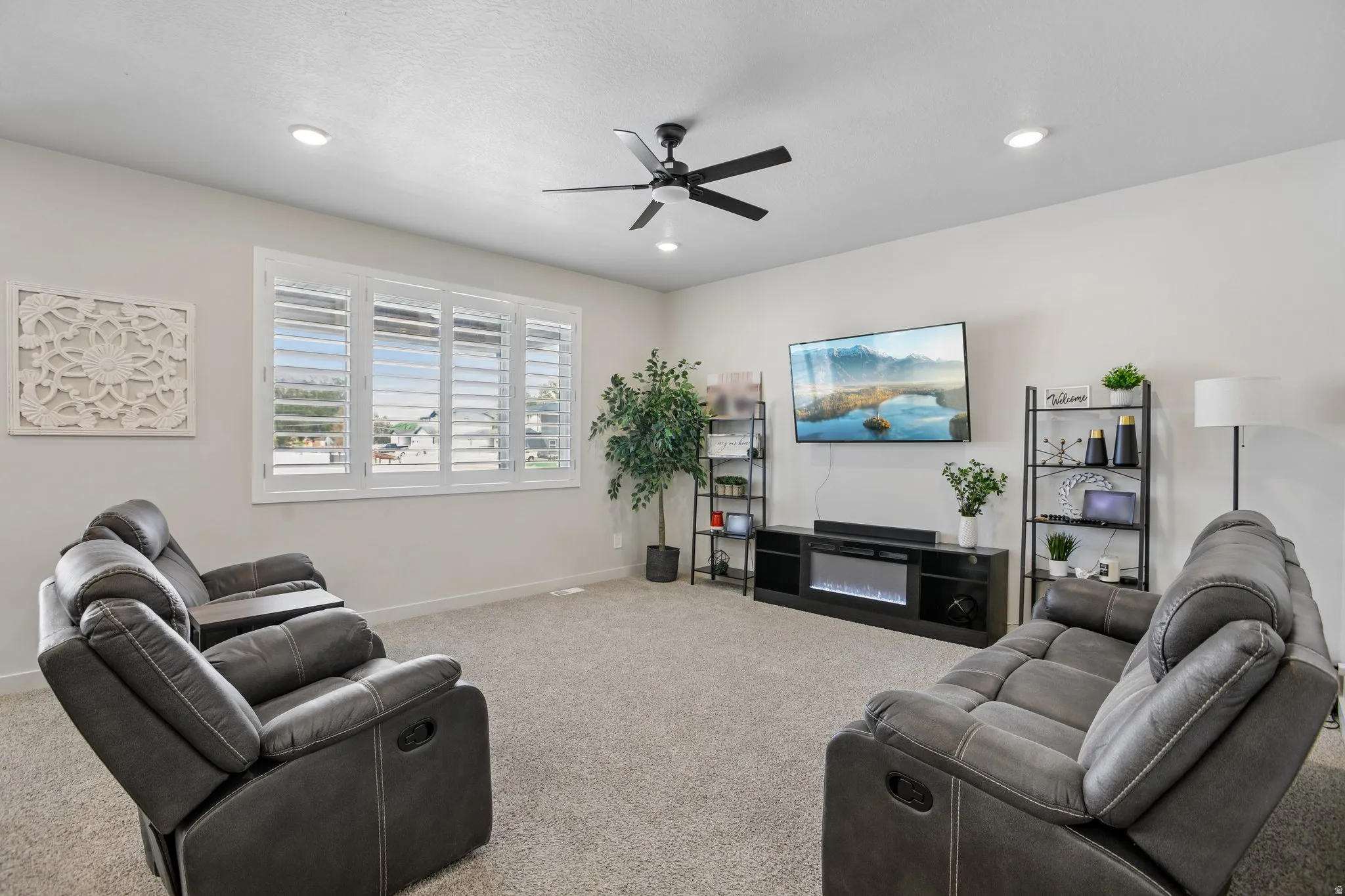 Spacious room with carpeted flooring, a ceiling fan, recessed lighting, and windows featuring plantation shutters