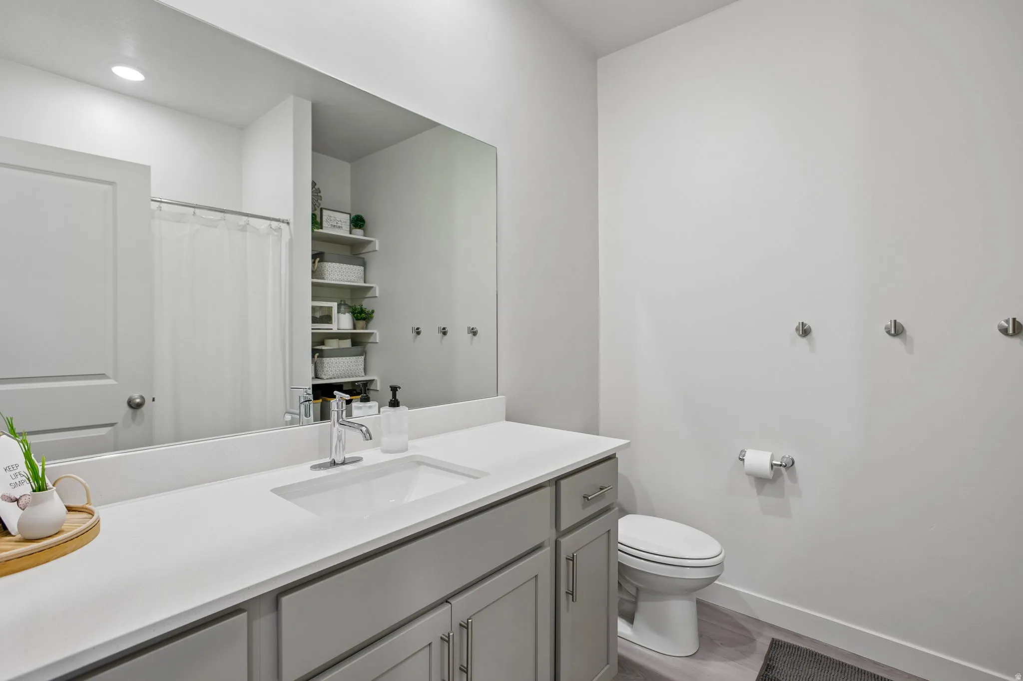 Vanity with a white countertop and gray cabinetry