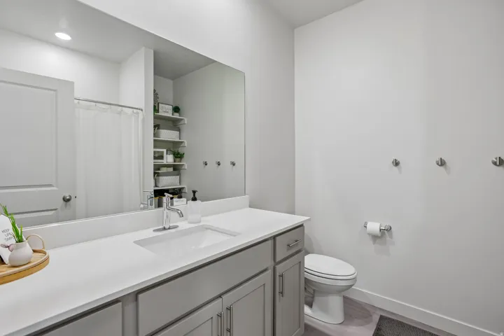 Vanity with a white countertop and gray cabinetry