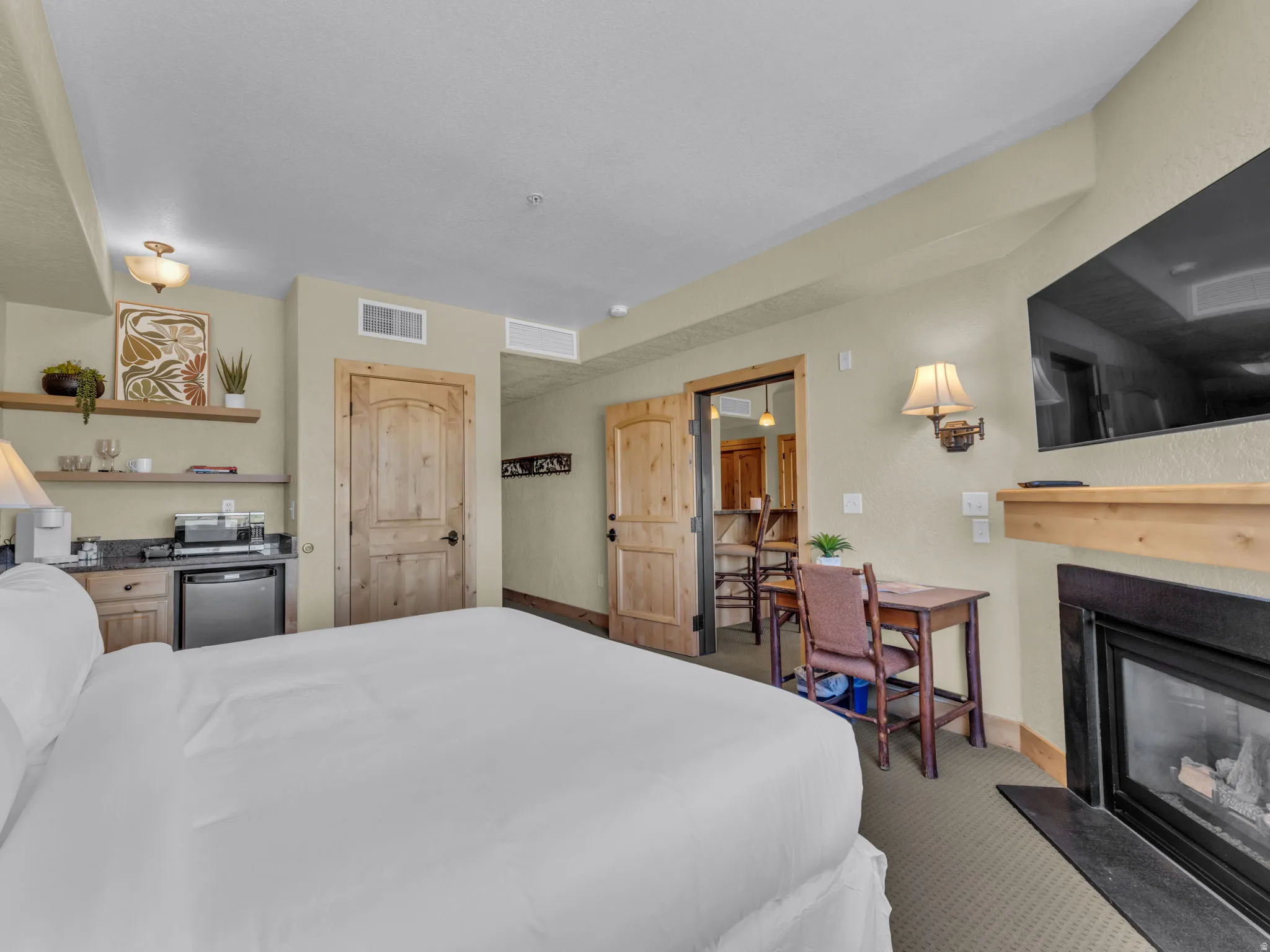 Built-in kitchenette with granite-style countertop, wood cabinetry, and shelving