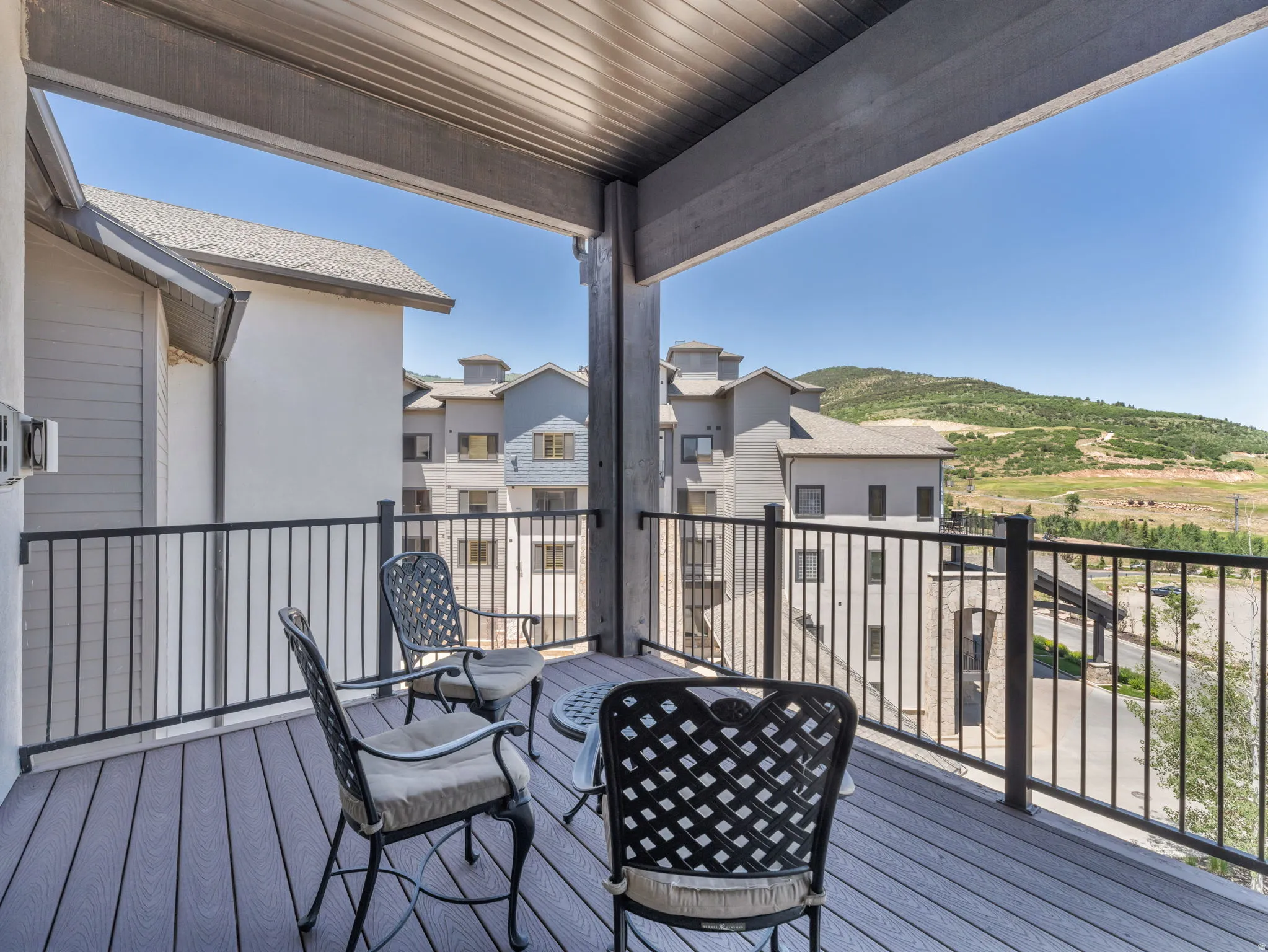 Covered balcony featuring composite decking and black metal railings