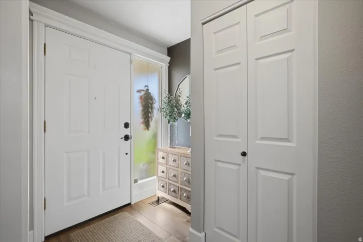 Entryway featuring a paneled door, wood-finish tile flooring, and bi-fold closet doors
