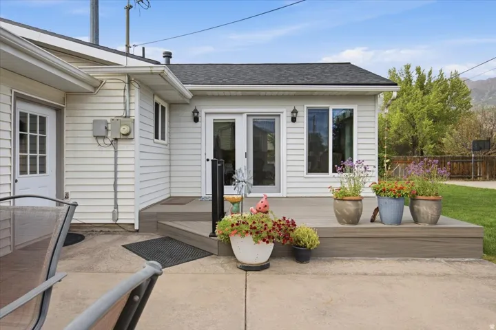 Composite deck with black railing, dual patio doors, and exterior lighting fixtures