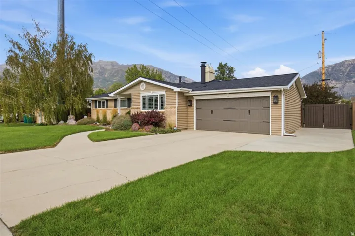 Single-story exterior with a two-car garage, concrete driveway, and a fenced side yard