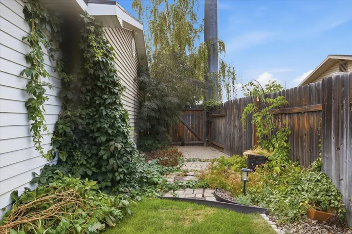 Expansive outdoor space featuring a wood fence, a gate, and a stone-paver pathway