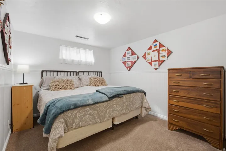 Carpeted flooring, white walls, white wainscoting, and a window with white blinds