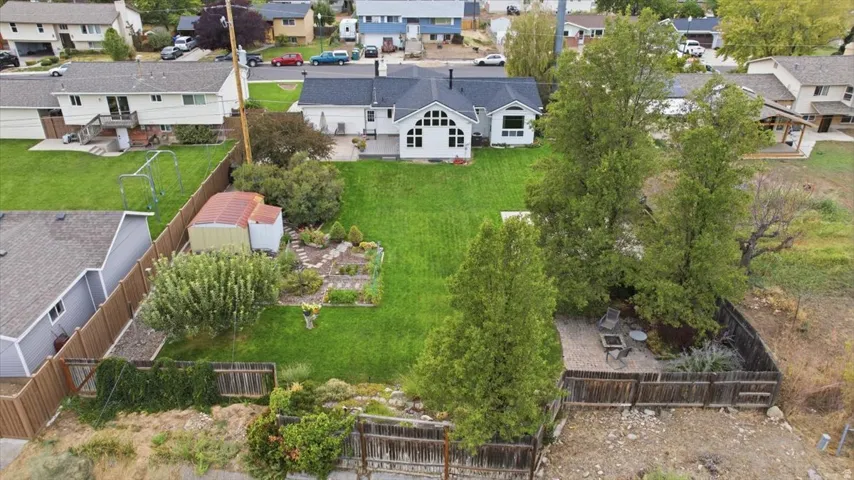 Expansive green lawn, established trees, and a dedicated garden area