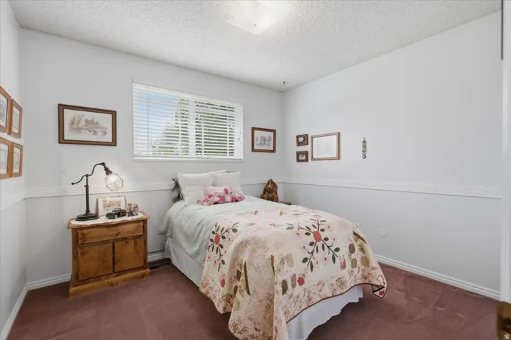 Single window with blinds, light-colored walls, ceiling-mounted lighting fixture, and a built-in wall accent