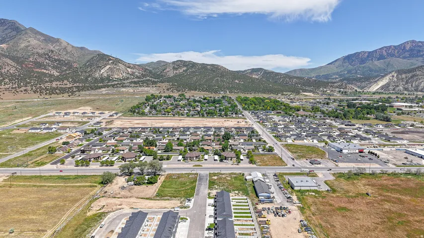 Expansive mountain backdrop with a residential area and developing land parcels