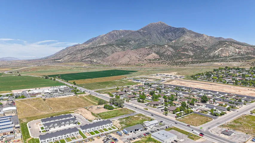 Expansive mountain backdrop with established residential areas and commercial buildings