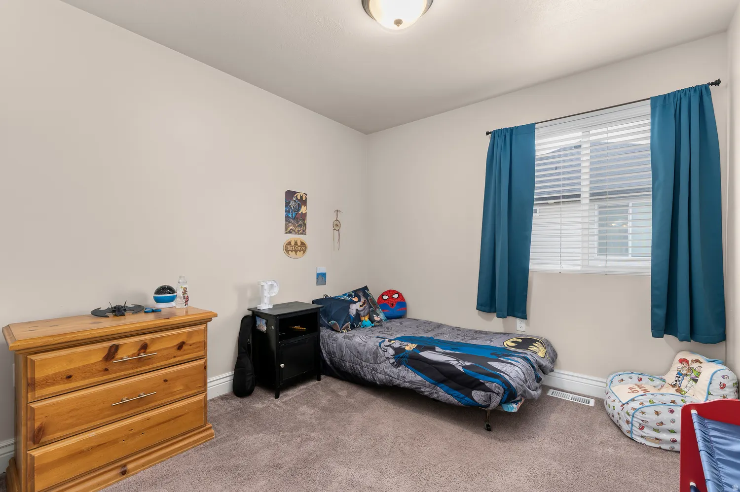 Neutral wall paint, window with horizontal blinds, ceiling-mounted light fixture, and carpeted flooring