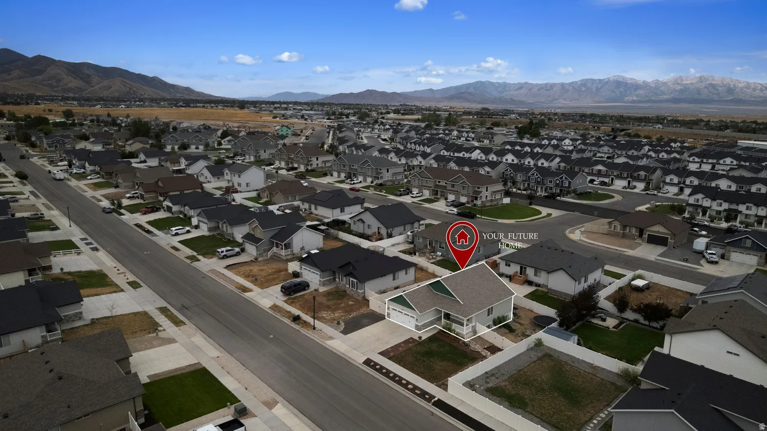 Aerial perspective of a developed residential neighborhood with distant mountain ranges