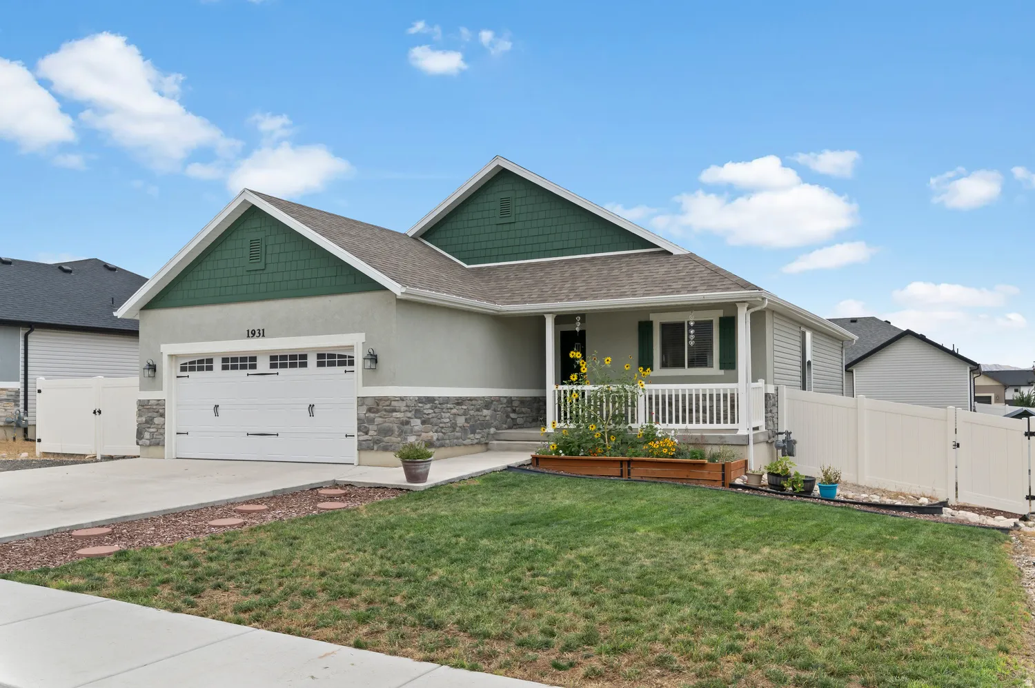 Ranch-style exterior with a covered porch, stone accent siding, and an attached two-car garage