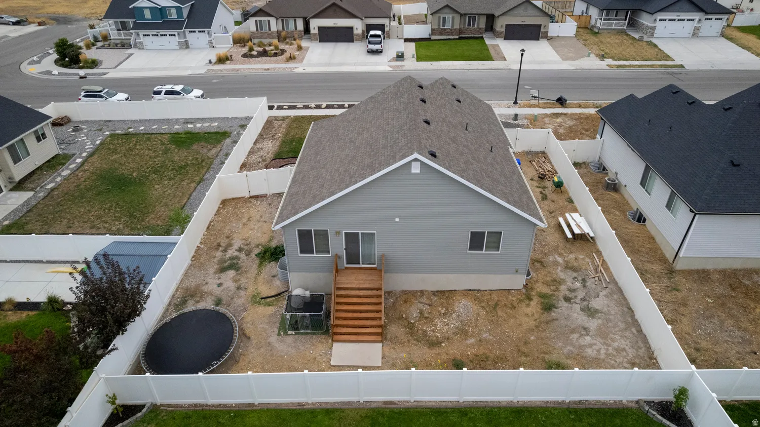 Rear exterior featuring a wood deck, sliding glass door, and a fully fenced yard
