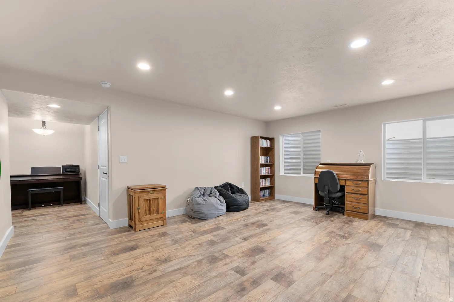 Spacious room with wood-finish flooring, recessed lighting, and two windows