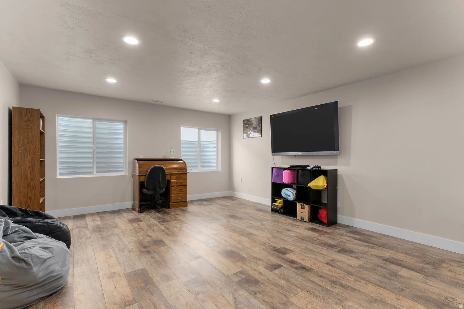 Recessed lighting, light-toned walls, and wood-finish flooring