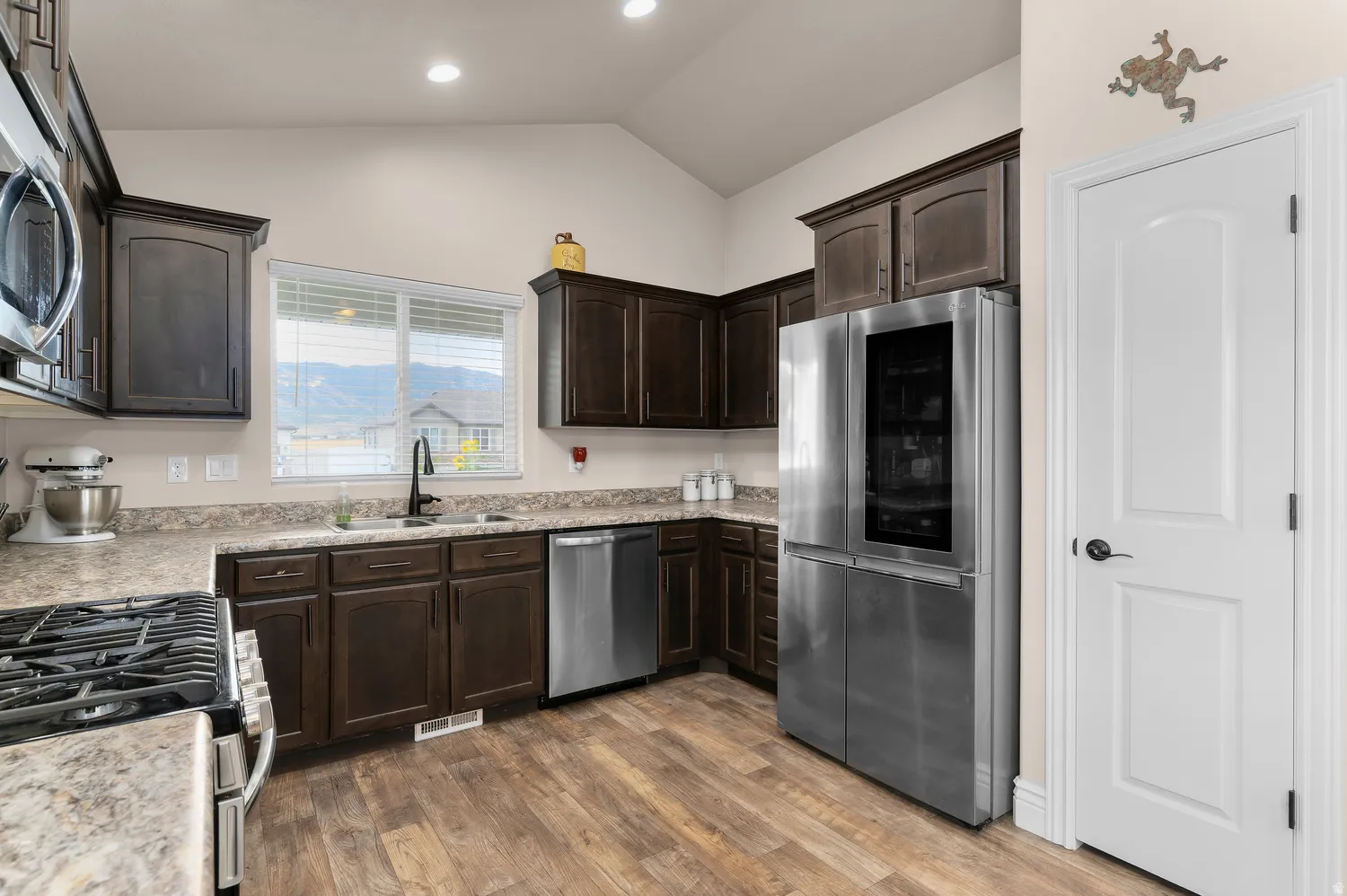 Kitchen featuring dark wood-finish cabinetry, light-toned countertops, and wood-finish flooring