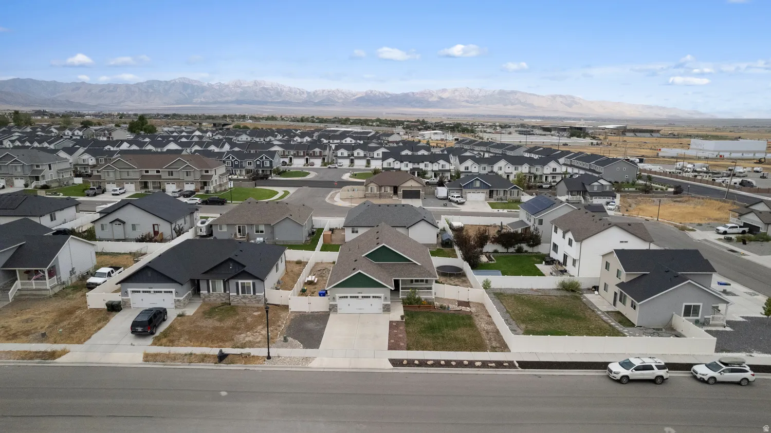 Residential neighborhood featuring various single-family homes, paved streets, and mountain scenery