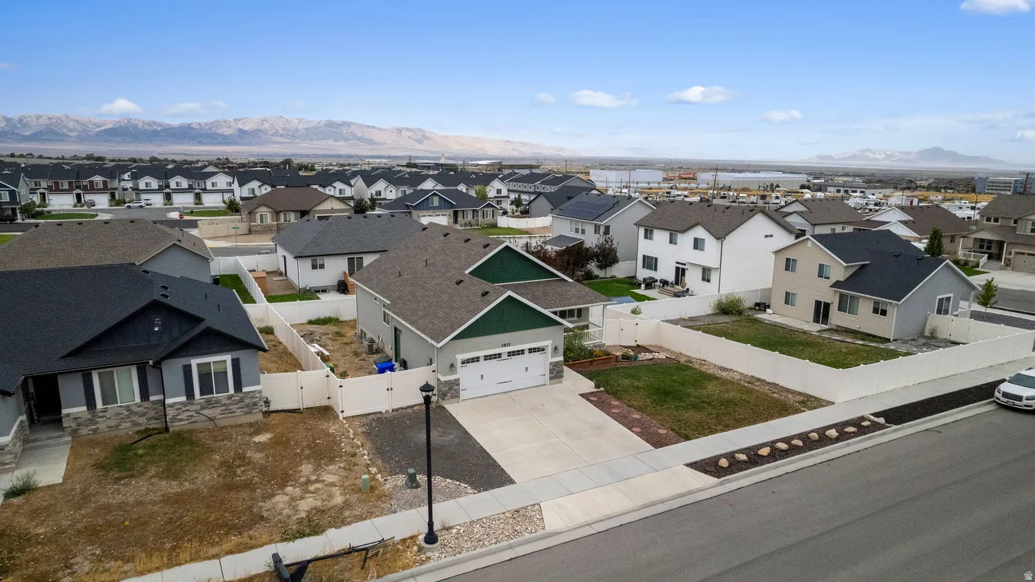 Single-story residence with an attached two-car garage, partial stone facade, and a fenced backyard