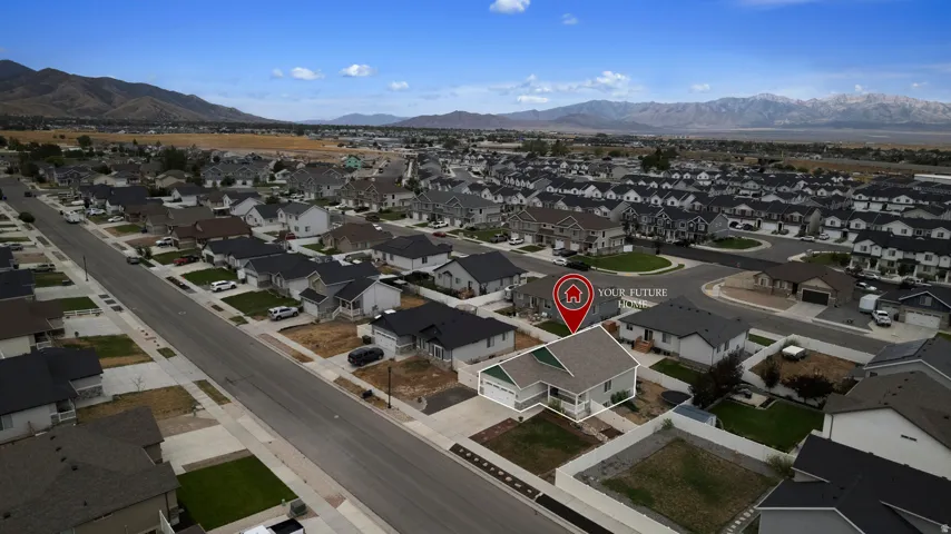 Aerial perspective of a developed residential neighborhood with distant mountain ranges
