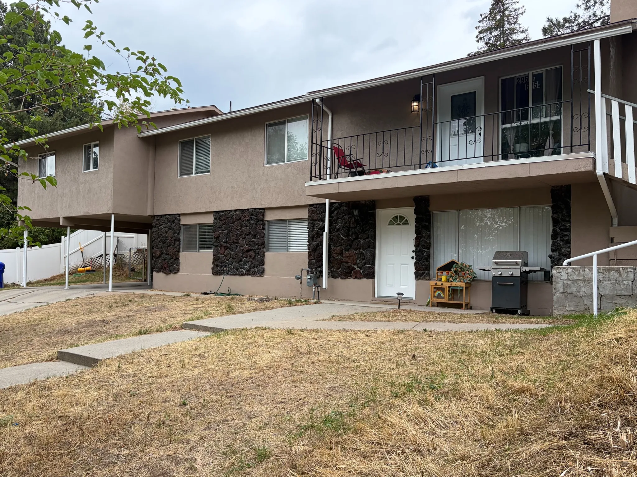 Multi-level exterior with stucco finish and stone accents