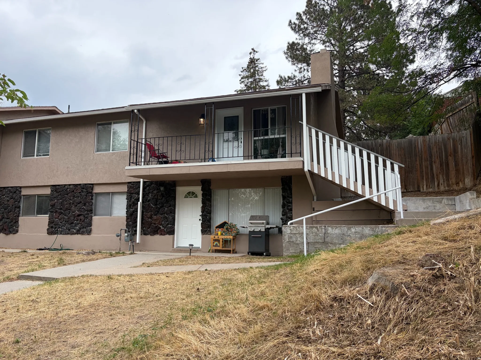 Two-story exterior with stucco siding and stone detailing