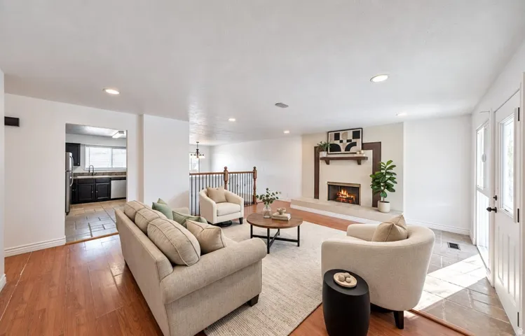 Recessed lighting, wood-finish flooring, and a fireplace with a mantel