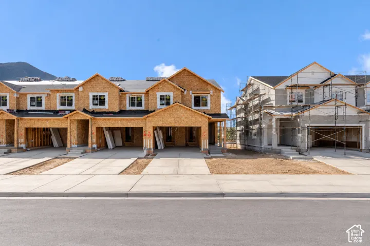 Multi-unit residential construction featuring multi-gabled rooflines, shingle roofing, installed double-pane windows, and concrete driveways