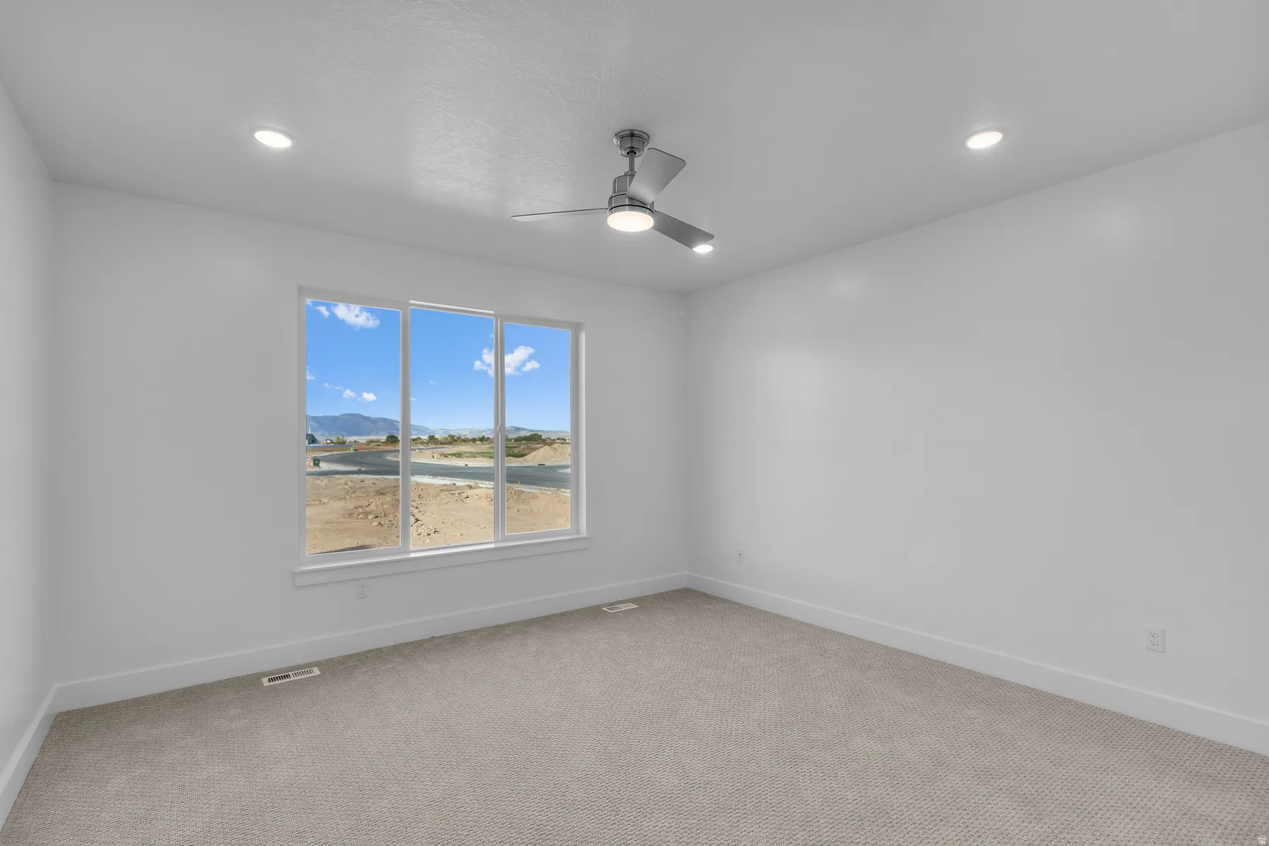 Large window with white trim, recessed ceiling lighting, a ceiling fan with integrated lighting, and neutral carpeting