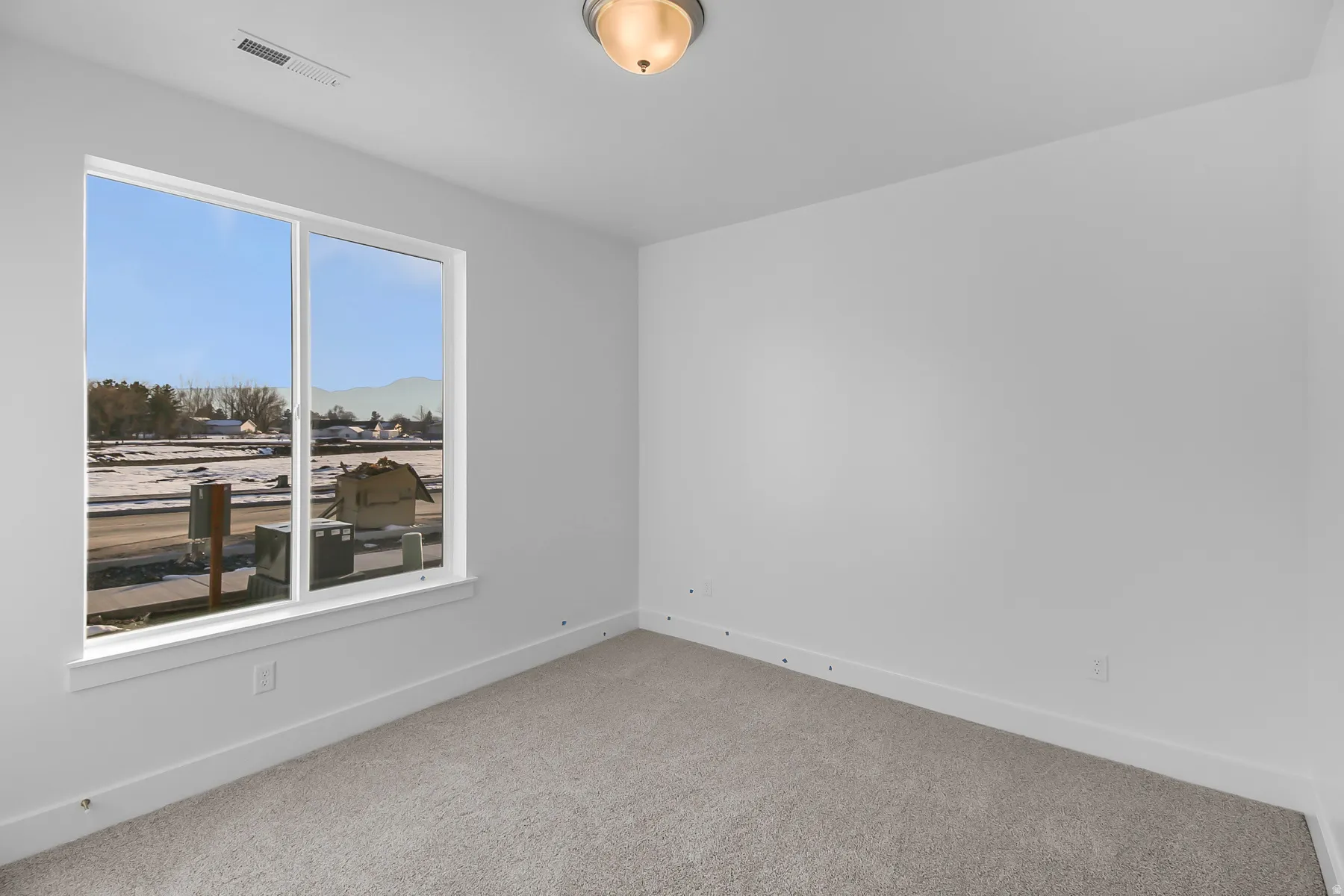 White walls, carpet flooring, and a large window