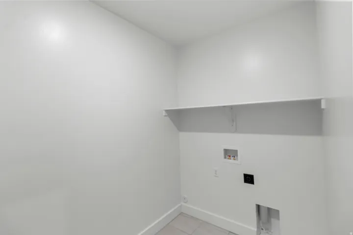 Utility area featuring a built-in shelf, appliance hookups, and tiled flooring