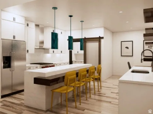 Gourmet kitchen with stainless steel appliances, a spacious island with seating, pendant lighting, extensive white cabinetry, and wood-finish flooring