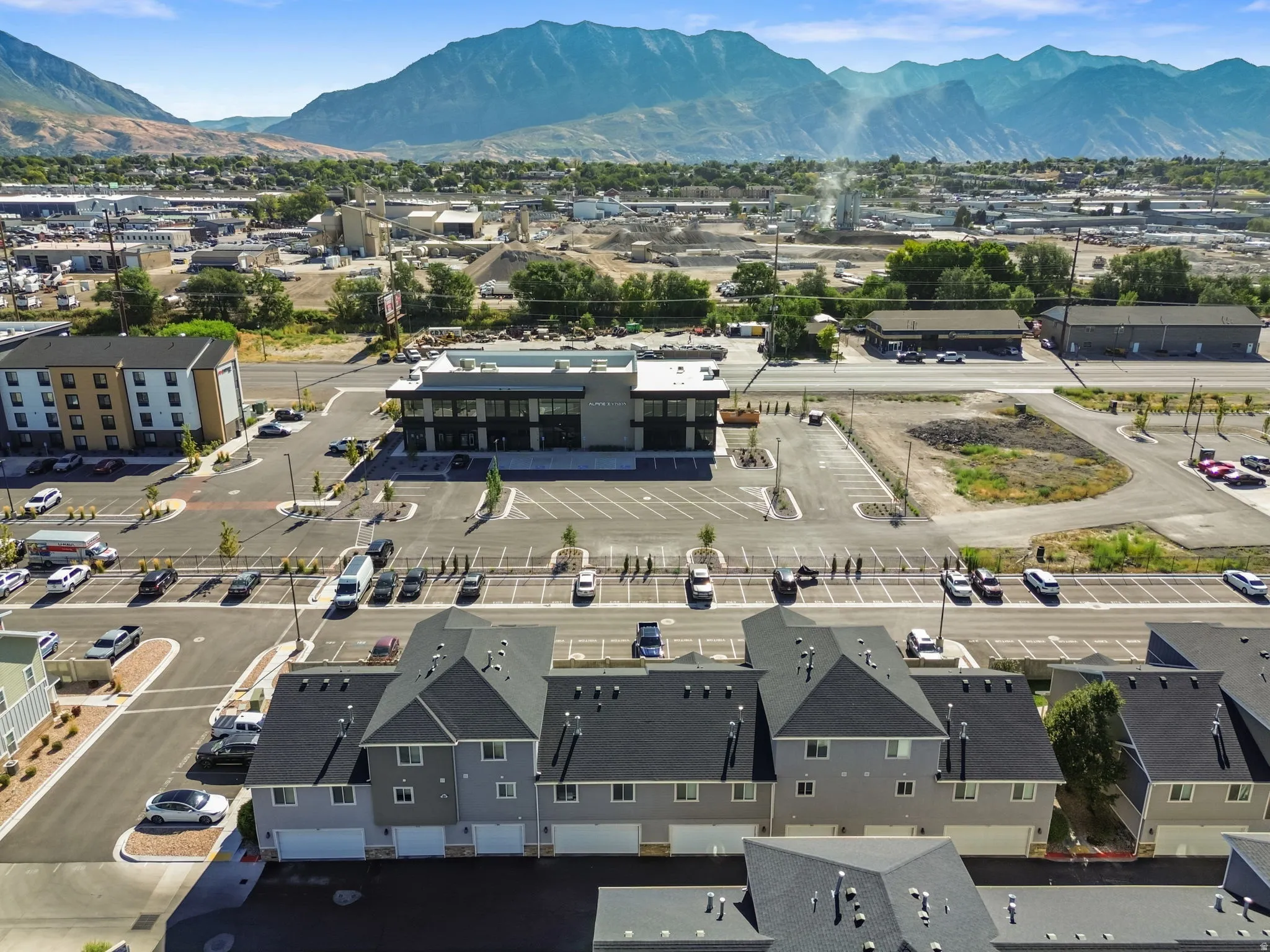 Modern townhome community featuring multi-level units, attached garages, and a mountain backdrop