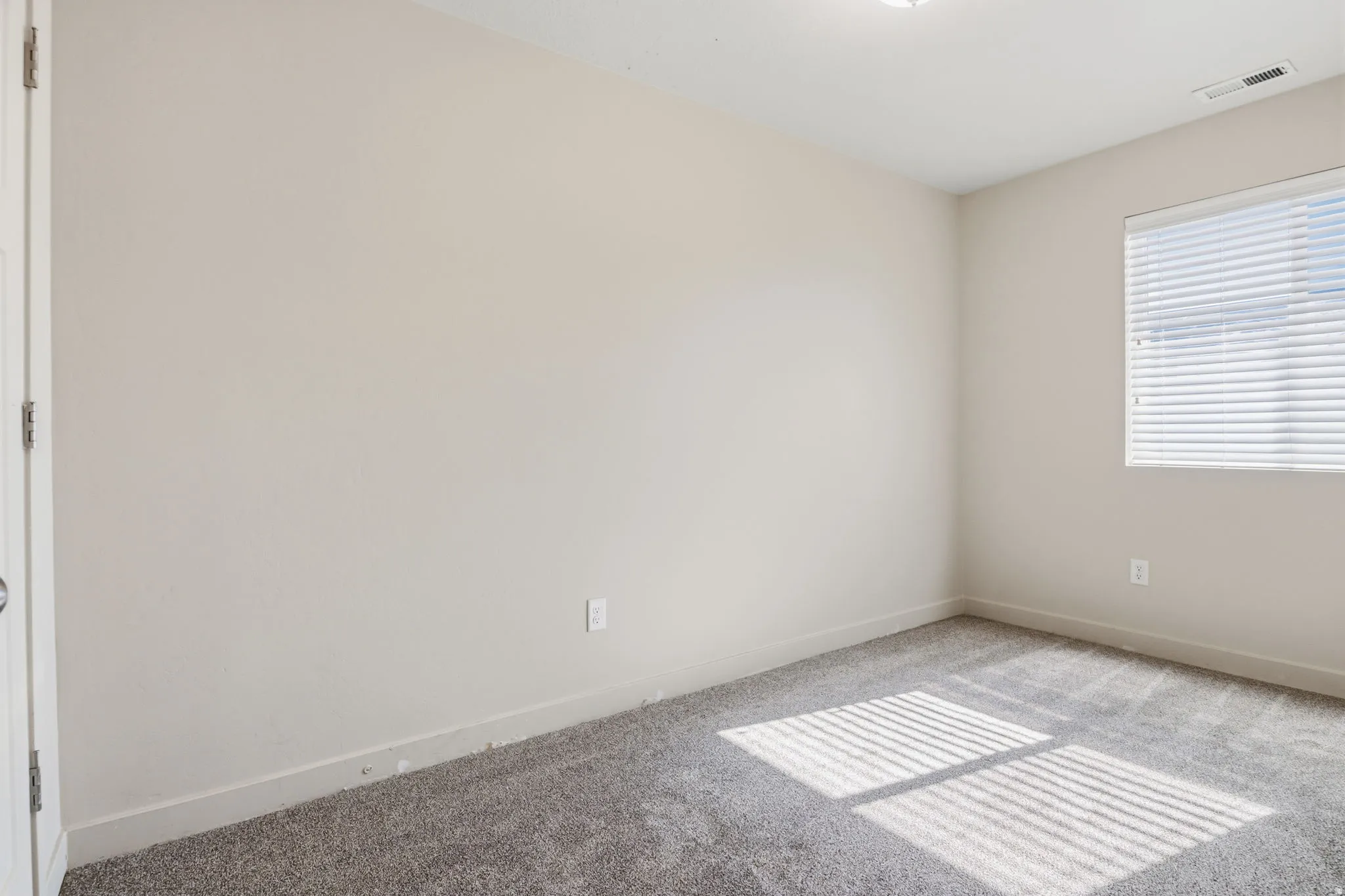 Neutral-toned walls complement plush carpeting