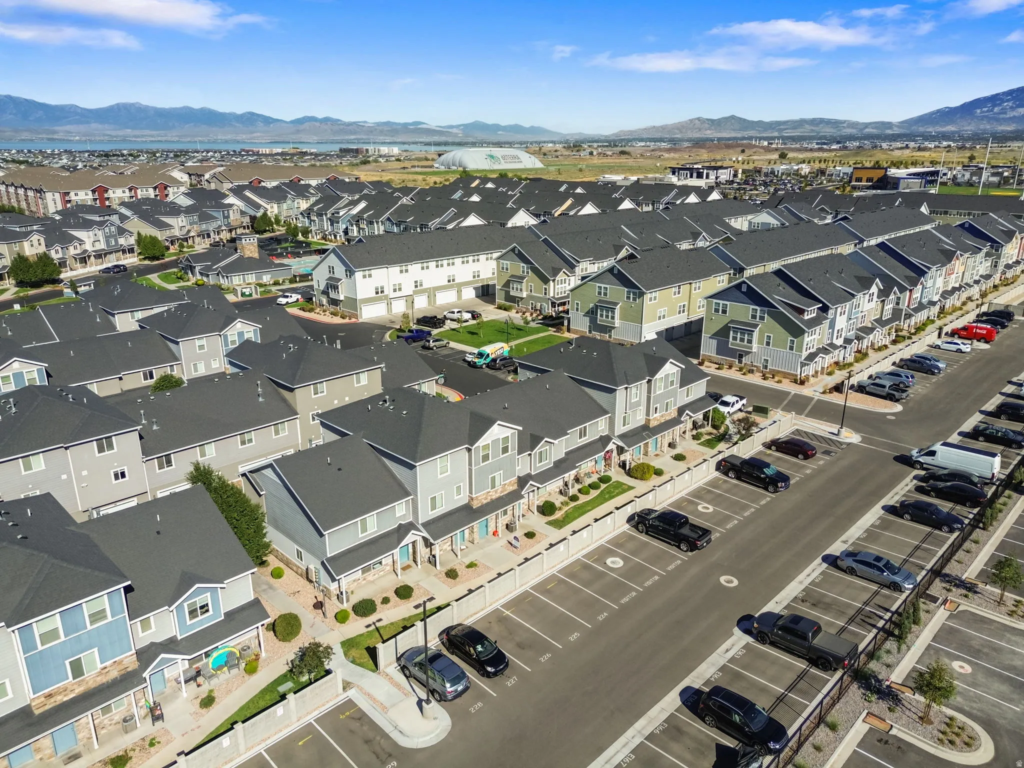 Multi-story townhomes with varied exterior finishes, ample off-street parking, and mountain scenery