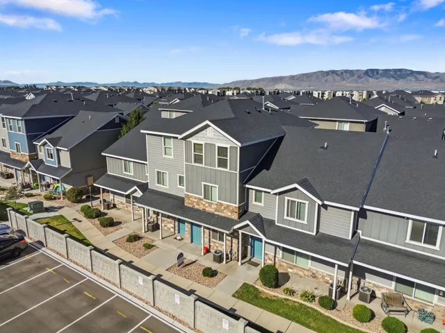 Multi-level exterior featuring horizontal siding, stone veneer accents, covered entryways, and a private patio space