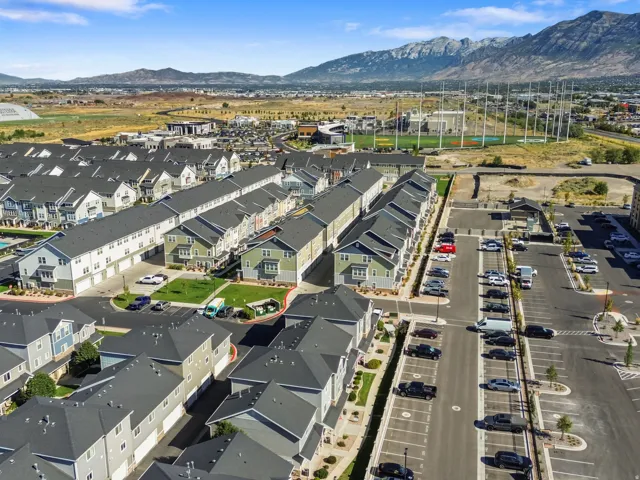 Contemporary townhome community with a mountain backdrop, multiple parking areas, and nearby recreational facilities