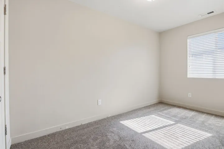 Neutral-toned walls complement plush carpeting
