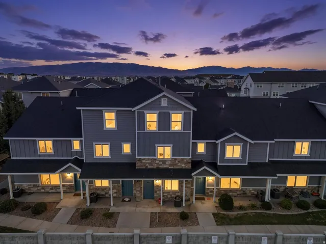 Multi-unit property with a stone and siding exterior, covered front porches, and individual entryways