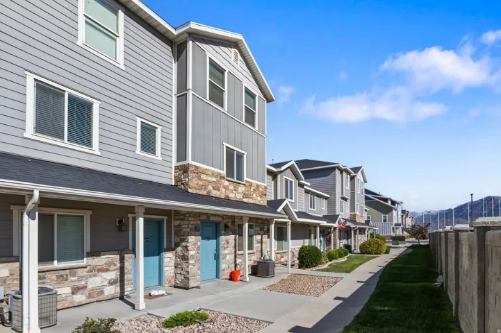 Multi-level exterior with horizontal siding and stone accents