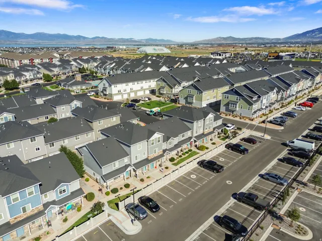 Multi-story townhomes with varied exterior finishes, ample off-street parking, and mountain scenery