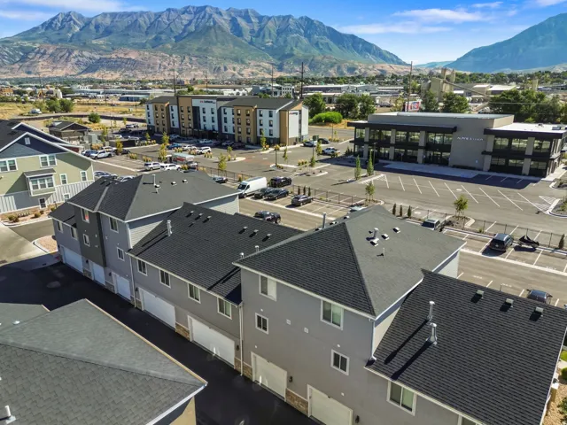Contemporary townhome exteriors featuring attached garages and dark shingle roofing