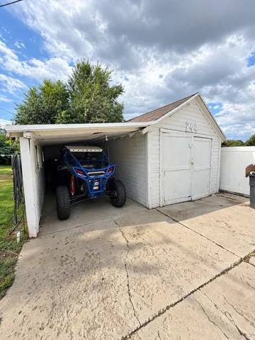Detached garage structure with a side carport