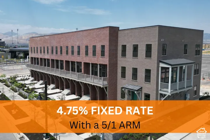 Multi-story brick exterior featuring recessed balconies, metal railing systems, mountain scenery, and landscaped ground-level common areas