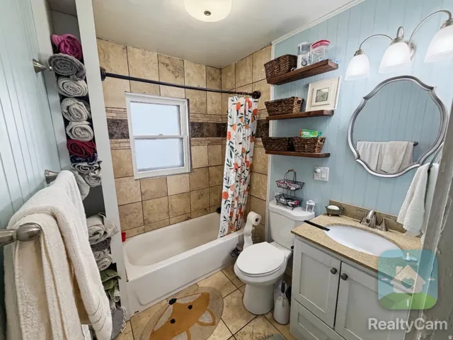 Bathroom featuring a vanity with an integrated sink, a mounted mirror, and open shelving