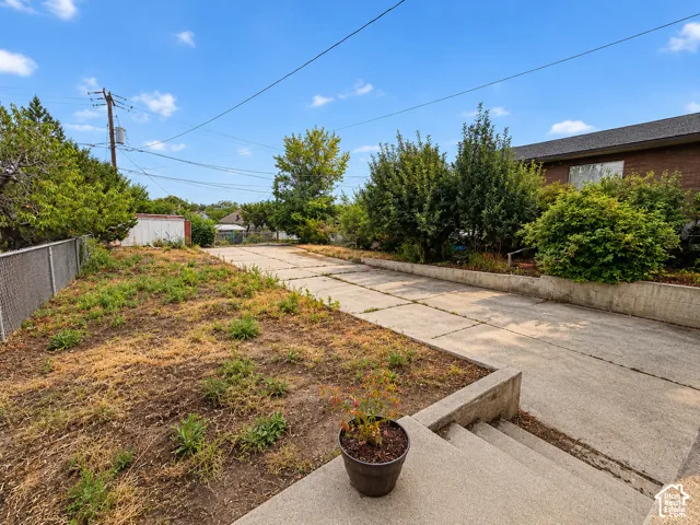 Concrete driveway, concrete retaining walls, and chain-link fencing
