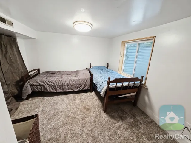Wall-to-wall carpeting, recessed window with wood trim, and overhead flush-mount lighting